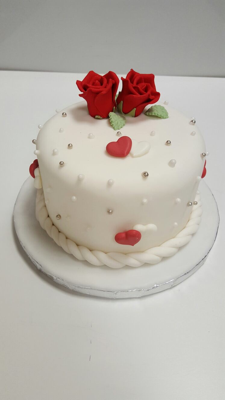 Torte mit roten Rosen und Herzdekor